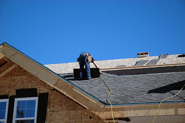 Professional roofing contractor repairing damaged shingles and roof structures