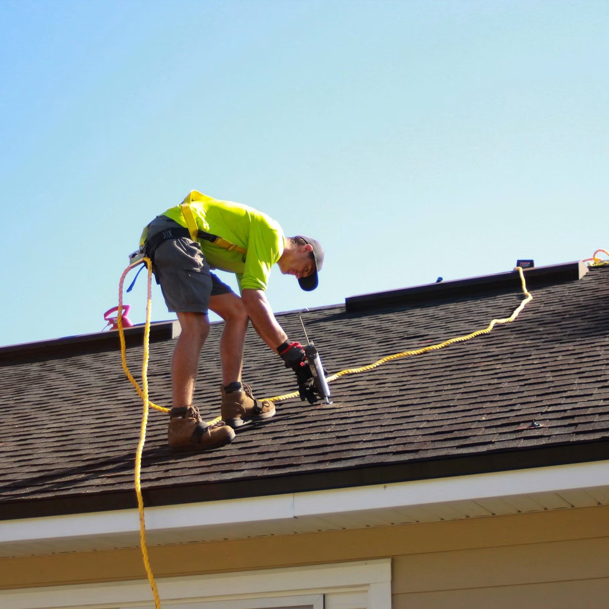 Roofing professional working directly on an asphalt shingle roof, representing Professional Roofing Repair in Wheat Ridge, CO