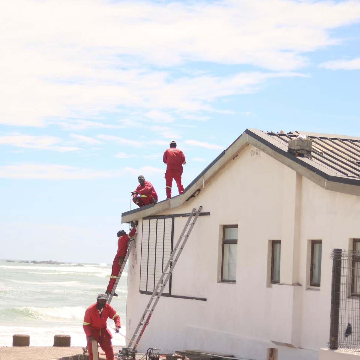 Roofing professionals working on a residential roof with ladders and repair equipment, representing Reliable Roofing Repair in Evergreen, CO.