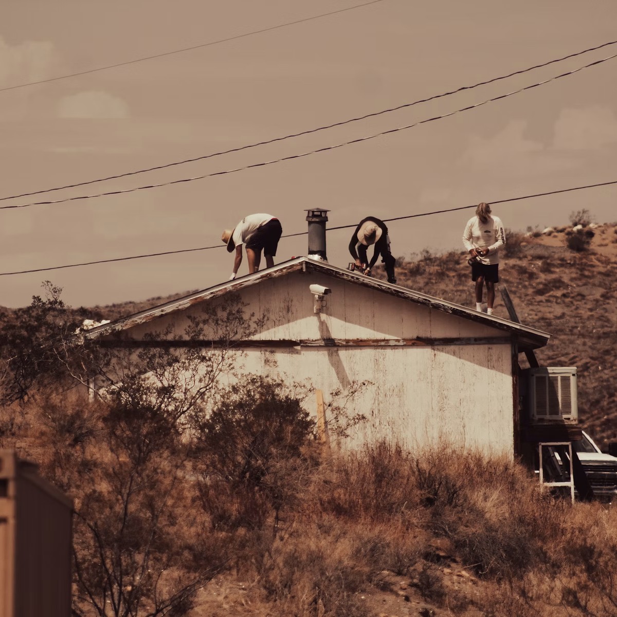 Roofing professionals working on a residential roof in a rural setting, representing Roofing Repair services near me.
