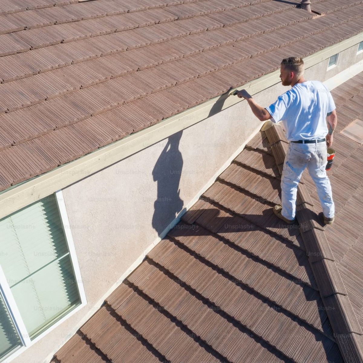 Professional roofer working on a residential tile roof, representing Roofing Company services near me.