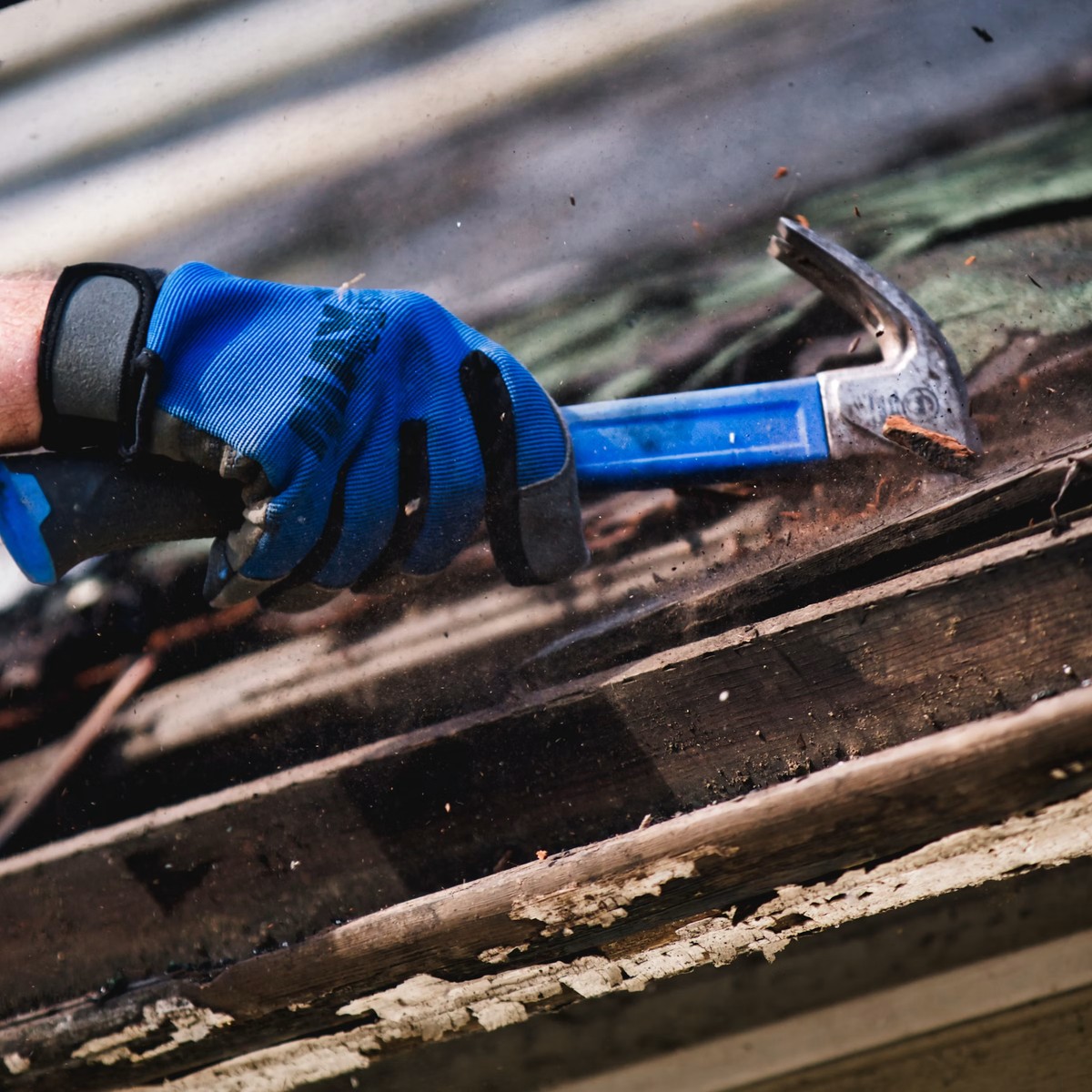 Close-up of a roofing professional using hand tools on exposed roofing materials, representing Professional Roofing Repair in Broomfield, CO.