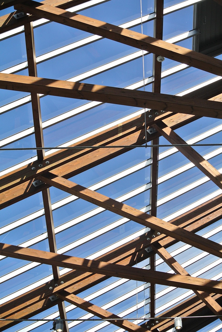Exposed wooden roof framing beneath transparent roofing panels for roofing services near me