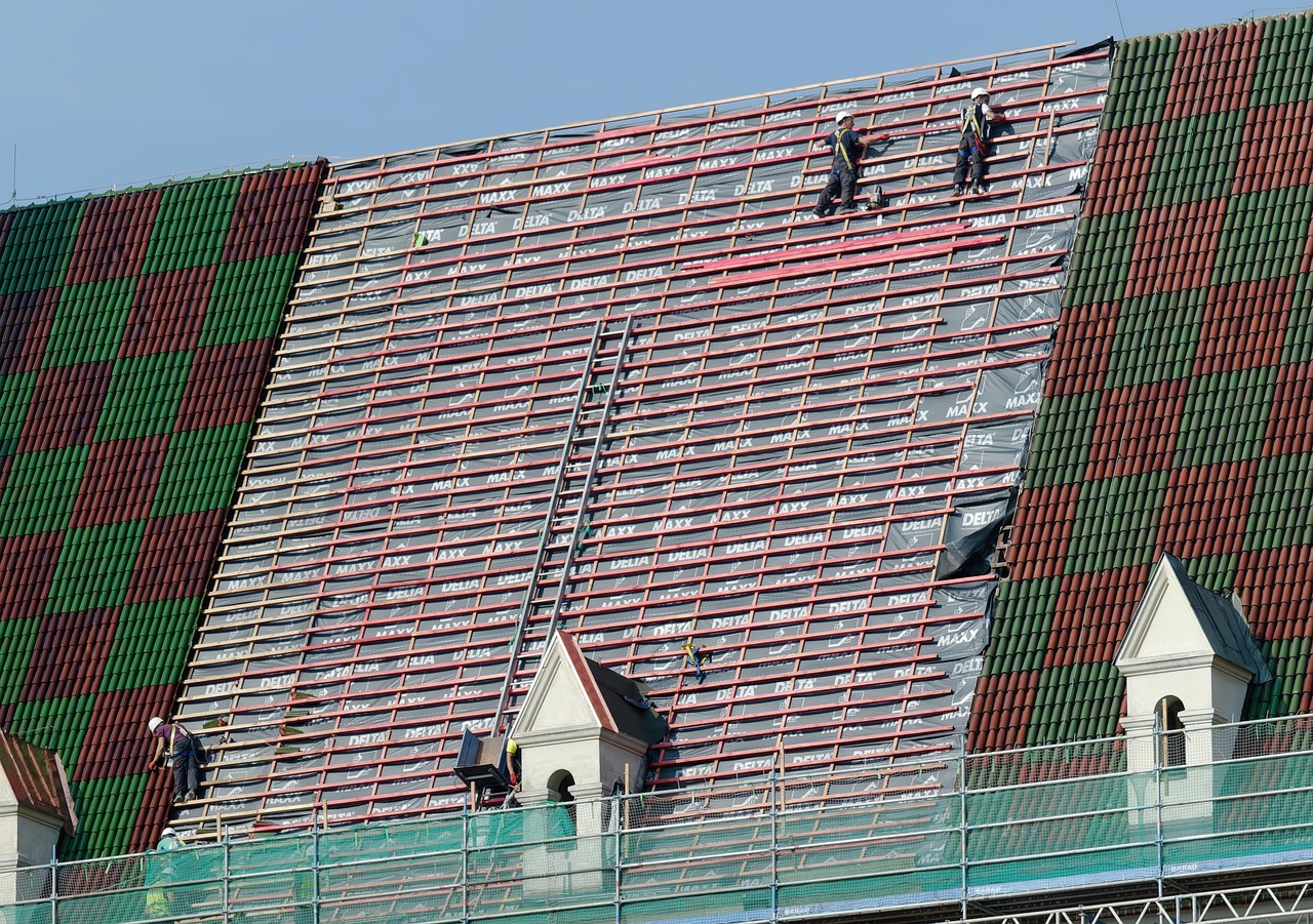 Roofing crew installing underlayment and battens on a steep roof for roofing services in Lafayette, CO