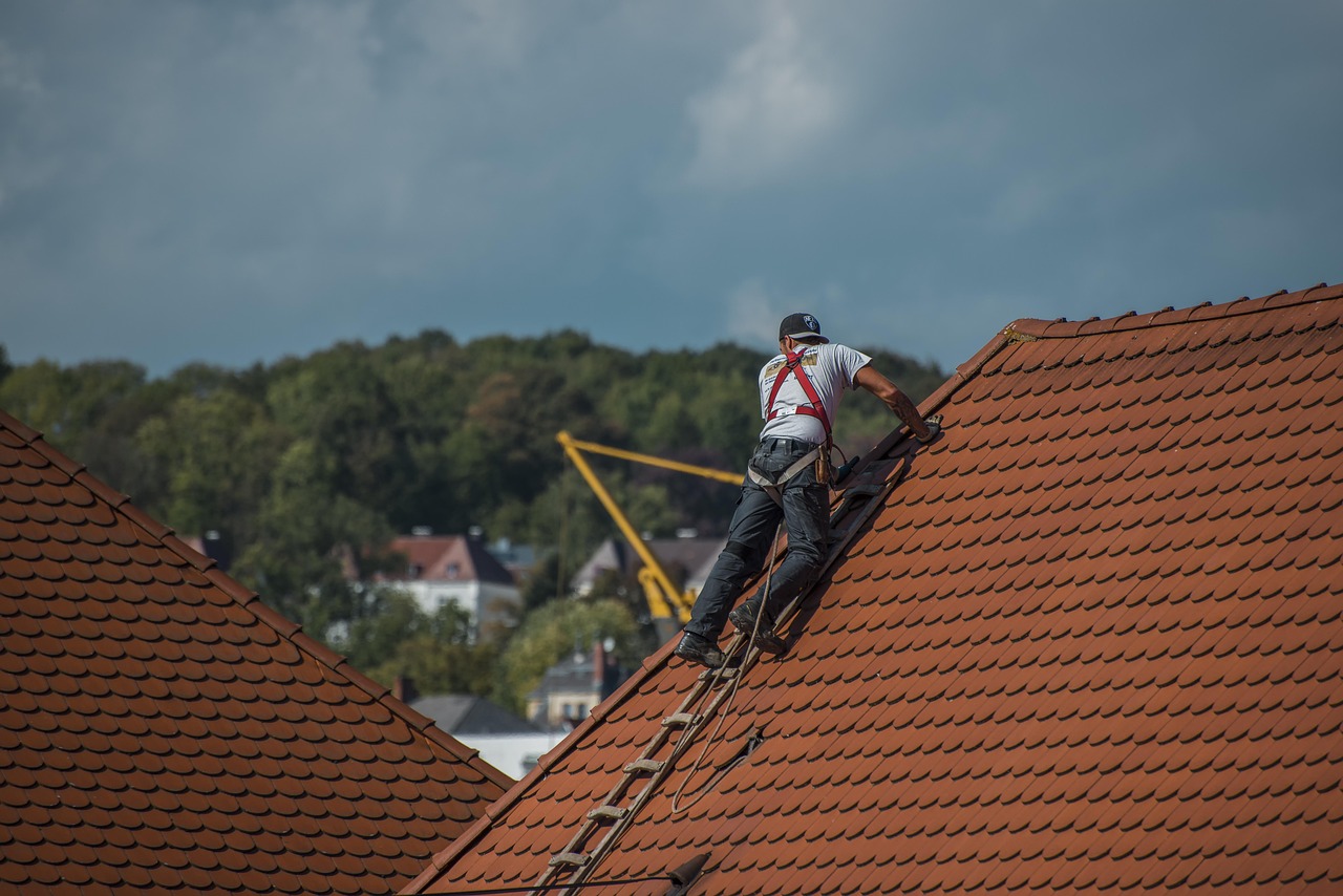 Roofing professional working on a steep tile roof for roofing services in Louisville, CO